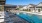 Large sparkling blue pool with a large pool deck and lounge chairs