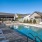 Large sparkling blue pool with a large pool deck and lounge chairs