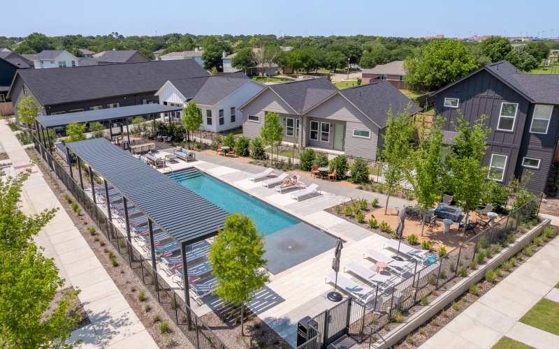 Resort inspired pool with tanning chairs and outdoor dining